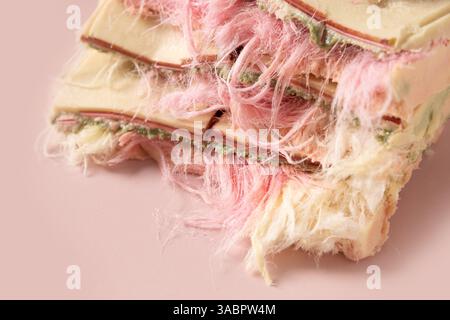 Trendy pink chocolate with airy filling ayer of white and pink pismaniye on pink background. Close up. Stock Photo