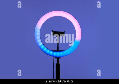 Ring lamp with holder for smartphone against purple background Stock Photo