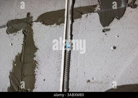 A detailed close up image showcasing a metal bar resting prominently on a textured concrete surface beneath it, creating an interesting visual contras Stock Photo