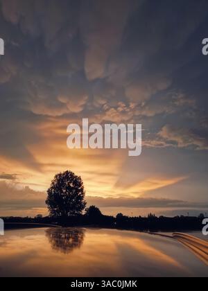 After the storm view with sunset rays piercing the wonderful Mammatus clouds Stock Photo