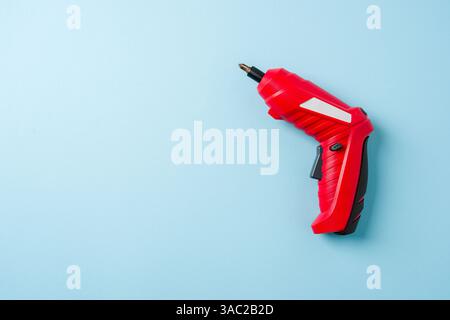 Top view of red cordless mini screwdriver on blue background Stock Photo