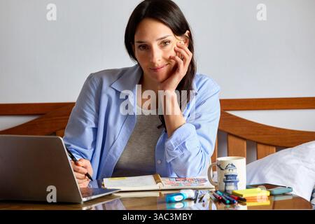 35-year-old woman studying at home, looking at camera Stock Photo