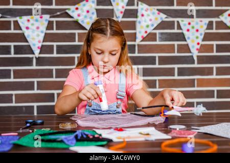 Cute preschooler girl makes art at a summer outdoor party. Stock Photo