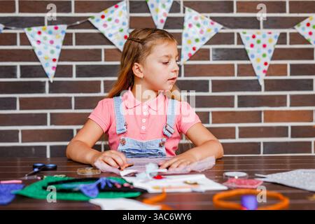Cute preschooler girl makes art at a summer outdoor party. Stock Photo