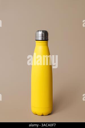 Yellow reusable stainless steel thermo bottle isolated on beige background. Plastic free.  Stock Photo