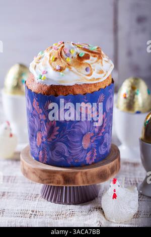 Easter cake, chocolate eggs in gold foil and chicken-shaped candles on a light background. Stock Photo