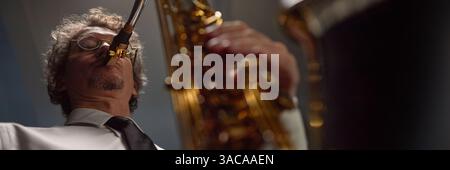 Website header shot of focused middle aged male saxophonist playing enchanting music during jazz concert on stage Stock Photo
