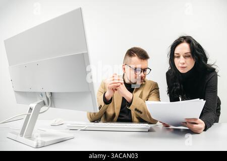 Two versatile business analysts discussing data management using a laptop. Concept consulting, training Stock Photo