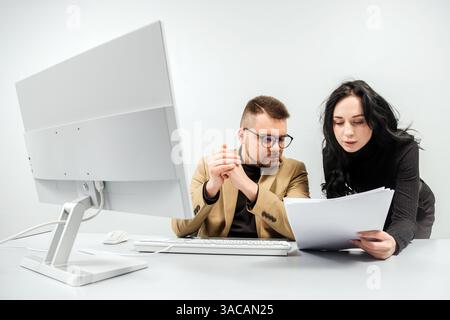Two versatile business analysts discussing data management using a laptop. Concept consulting, training Stock Photo