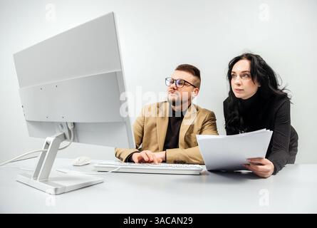 Two versatile business analysts discussing data management using a laptop. Concept consulting, training Stock Photo