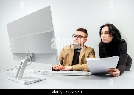 Two versatile business analysts discussing data management using a laptop. Concept consulting, training Stock Photo