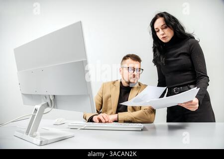Two versatile business analysts discussing data management using a laptop. Concept consulting, training Stock Photo