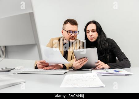 Two members of a finance team working together on a project during a brainstorming meeting. Concept collaborative teamwork, strategy planning Stock Photo