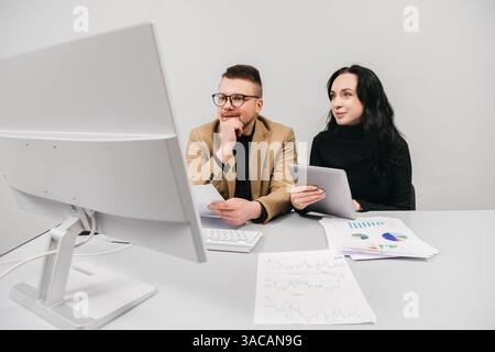 Two members of a finance team working together on a project during a brainstorming meeting. Concept collaborative teamwork, strategy planning Stock Photo