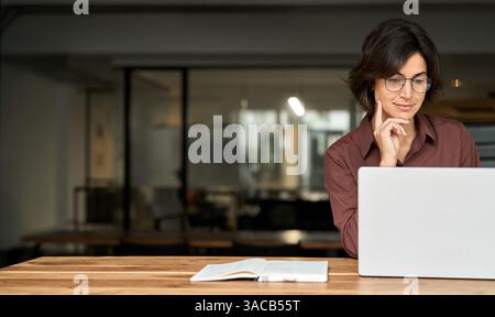 Busy young business woman using laptop working in office. Copy space Stock Photo