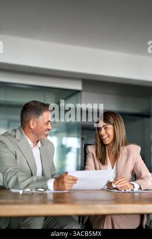 Two happy professional executives discussing financial documents in office. Stock Photo