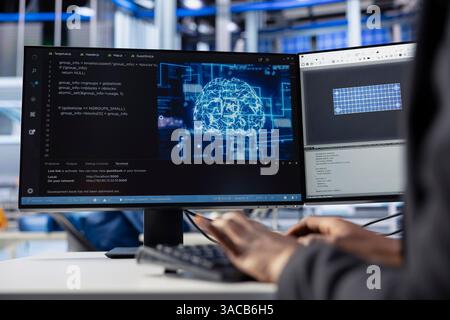 Engineer coding AI powered software at desk in solar energy plant, optimizing performance. Technician integrating artificial intelligence in photovoltaics factory production to enhance efficiency Stock Photo