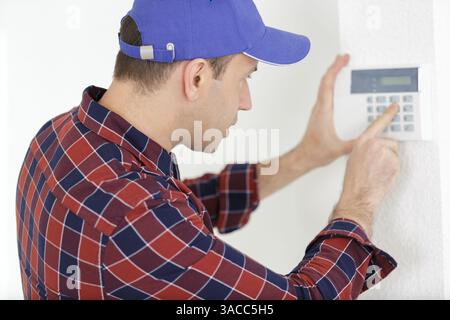 male technician installing alarm system indoors Stock Photo