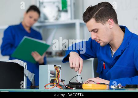 team of students examining and repairing computer parts Stock Photo