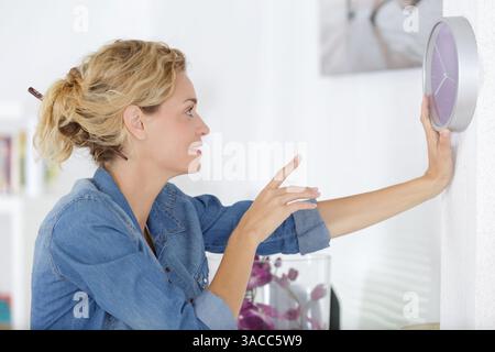woman changing time on big wall clock Stock Photo