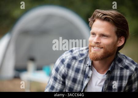 handsome cheerful man camping outdoors Stock Photo