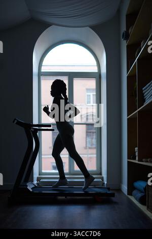 Exercising on Treadmill in Front of Large Window Stock Photo