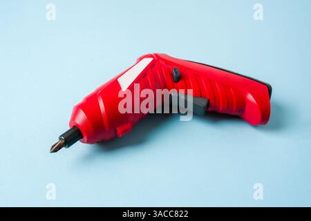 Top view of red cordless mini screwdriver on blue background Stock Photo