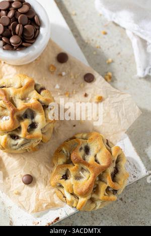 Butter Cookies with Chocolate Chips on Beige Tiles – Soft Shadows, White Marble Bowl with Sea Salt Flakes Stock Photo