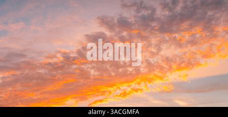 Awesome sunset soft orange pink clouds of pastel tones. Peaceful weather textured sky. Gorgeous wallpaper. Bright epic sky dramatic evening light pano Stock Photo
