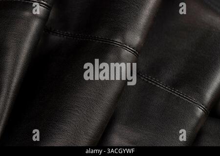 synthetic black leather fabric for the manufacture of clothing, a part of synthetic fabric used for sewing trousers and other types of fashionable clo Stock Photo