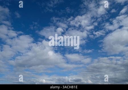 bright blue sky white fluffy clouds Stock Photo