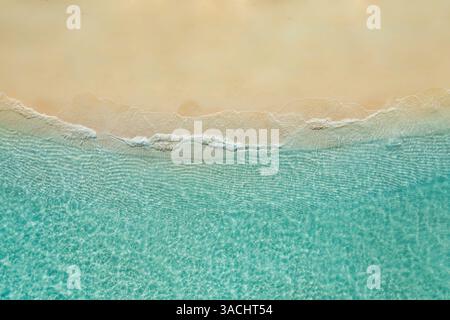 Top view from drone sunny sea aerial view, amazing tropical nature background. Beautiful bright sea with waves splashing and beach sand shore coast Stock Photo