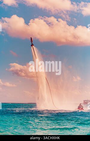 Flyboard Rider Professional pro fly board rider in tropical sea, water sports concept ...