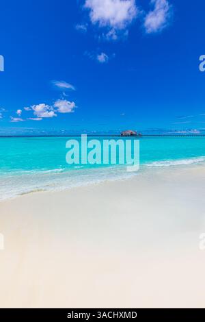 Beautiful sandy beach with white sand and closeup calm wave of turquoise ocean. Sunny day on background white clouds in blue sky. Island in Maldives Stock Photo