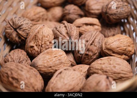 Close-up of whole walnuts in a wicker basket. Stock Photo