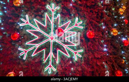 Big glowing snowflake close-up on Christmas tree, Bright and beautiful New Year and Christmas decorations Stock Photo
