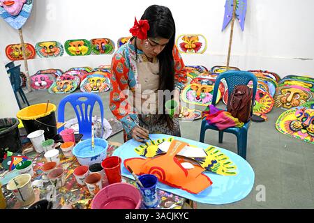 Student of Faculty of Fine arts of Dhaka University painting masks for colorful preparation to celebrate upcoming Bengla New Year 1432 in Dhaka, Bangladesh, on April 04, 2025. Pahela Baishakh (the first day of the Bangla month) can be followed back to its origins during the Mughal period when Emperor Akbar introduced the Bangla calendar to streamline tax collection while in the course of time it became part of Bengali culture and tradition. Stock Photo