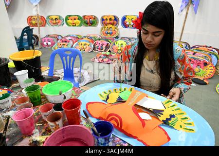 Student of Faculty of Fine arts of Dhaka University painting masks for colorful preparation to celebrate upcoming Bengla New Year 1432 in Dhaka, Bangladesh, on April 04, 2025. Pahela Baishakh (the first day of the Bangla month) can be followed back to its origins during the Mughal period when Emperor Akbar introduced the Bangla calendar to streamline tax collection while in the course of time it became part of Bengali culture and tradition. Stock Photo