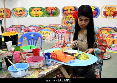 Student of Faculty of Fine arts of Dhaka University painting masks for colorful preparation to celebrate upcoming Bengla New Year 1432 in Dhaka, Bangladesh, on April 04, 2025. Pahela Baishakh (the first day of the Bangla month) can be followed back to its origins during the Mughal period when Emperor Akbar introduced the Bangla calendar to streamline tax collection while in the course of time it became part of Bengali culture and tradition. Stock Photo