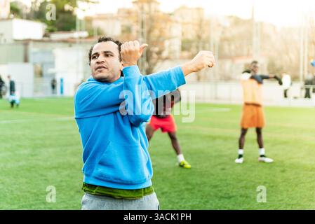 Young middle east arab man training in a football pitch. Young athlete practicing in a soccer field doing sport and exercise Stock Photo