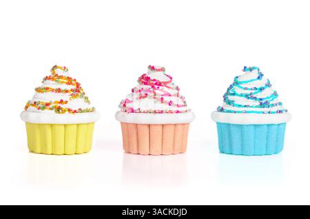 Isolated cupcakes in a row. Fake small cupcakes miniatures made with pearls and glitter. Bakery and confectionary background. Selective focus. White b Stock Photo