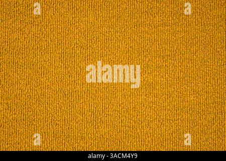 Fabric texture with yellow-orange color as background template made of fabric, carpet or textile Stock Photo