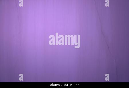 Surface of a purple stone wall with a crack in the wall Stock Photo