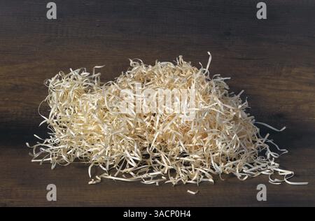 Image of a pile of wood shavings on a brown background. Stock Photo