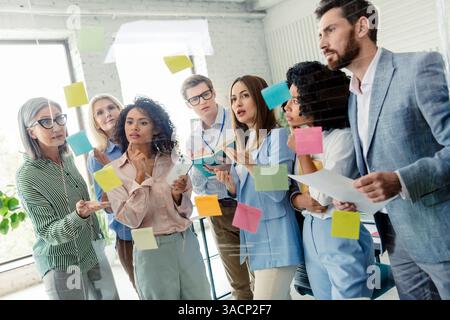 Diverse team collaborating on a creative project in a bright office space Stock Photo