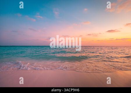 Tropical beach at sunset, vibrant skies reflecting on calm water sand, gentle waves splash shore, serene atmosphere under colorful sky, peaceful sea Stock Photo