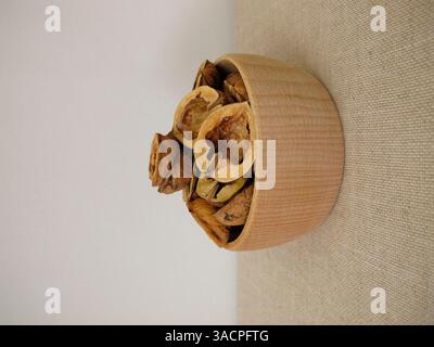 Craft materials Nutshells made from halved walnut shells in a wooden bowl Stock Photo