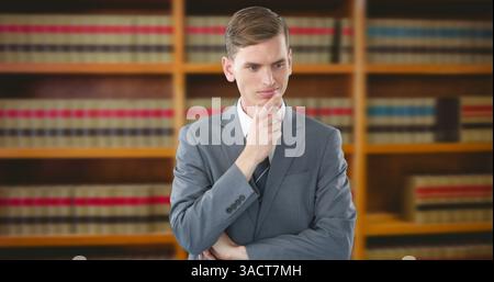 Businessman in suit thinking deeply in front of bookshelf in office Stock Photo
