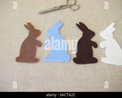 Four Easter bunnies cut out of colored felt with scissors for Easter Stock Photo