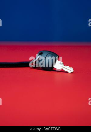Close up of minimal Black key isolated on blue and red background, Stock Photo